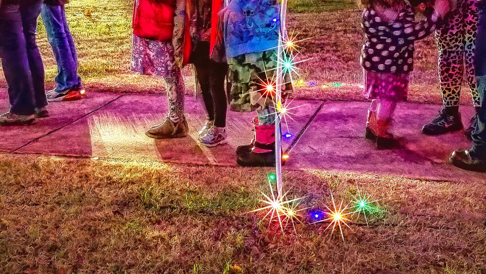 Families walking around the park looking at the trees in the Christmas Tree decorating contest.