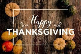 Pumpkins on a wood board with Happy Thanksgiving written on top