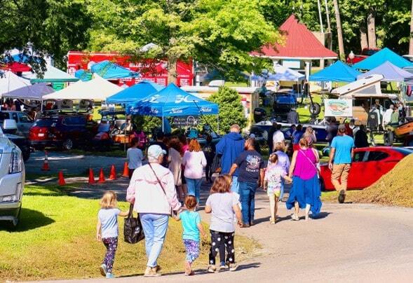 crowd of people walking into Big Spring Park heading to the Cotter Troutfest