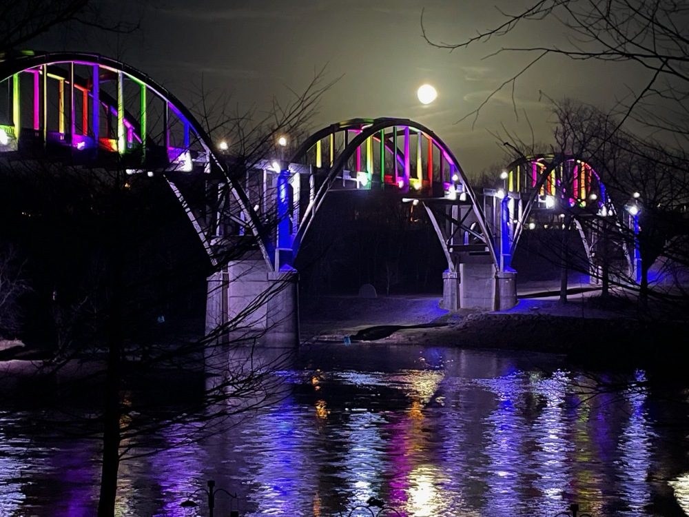 Bridge lit in multiple colors of magenta, blue, green, yellow