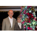 Peter and Jan Peitz stand smiling in front of the Christmas tree.