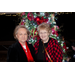 2 women stand together, smiling in front of the Christmas tree.